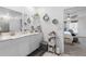 Bright bathroom featuring double sinks, white cabinetry, hexagon wall decor, and a glimpse into bedroom at 389 Singing Sands Cir, Lake Wales, FL 33859