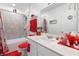 Stylish bathroom features a red accent decor, a shower, a toilet and a sink at 389 Singing Sands Cir, Lake Wales, FL 33859