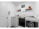 Well-organized laundry room with modern washer, dryer, storage cabinet and stylish decorative wall art at 389 Singing Sands Cir, Lake Wales, FL 33859