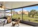 Inviting screened-in patio with ceiling fan, comfy seating, and serene views at 389 Singing Sands Cir, Lake Wales, FL 33859