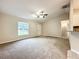 Bright living room with a ceiling fan, carpeted floors and views of front yard and entryway at 4887 Sw 159Th Lane Rd, Ocala, FL 34473