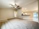 Spacious living room featuring carpet floors, ceiling fan, and an open floor plan to the kitchen and dining areas at 4887 Sw 159Th Lane Rd, Ocala, FL 34473