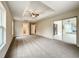 Spacious main bedroom with tray ceiling, large sliding doors to porch, and neutral carpeting at 4887 Sw 159Th Lane Rd, Ocala, FL 34473
