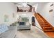Bright living room featuring wood staircase, cozy seating, and a view to a loft area at 940 Fenton Ln # 7, Lakeland, FL 33809