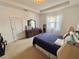 Comfortable bedroom with tray ceiling, carpet, dresser, and natural light from the window at 7055 Heatherbrook Dr, Lakeland, FL 33809