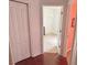 Hallway leading to bedroom with hard wood flooring and linen closet at 7055 Heatherbrook Dr, Lakeland, FL 33809