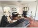 Cozy living room featuring hardwood floors, comfortable seating, and a large television at 7055 Heatherbrook Dr, Lakeland, FL 33809
