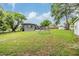 Large backyard with play structure, grassy area, and mature trees at 3120 S Polk Ave, Lakeland, FL 33803