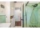 Nicely-tiled bathroom with mint green accents, an updated shower, and a white vanity at 3120 S Polk Ave, Lakeland, FL 33803
