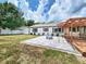 Wide view of backyard featuring the paver patio, fire pit, wooden pergola, and green lawn at 4102 Stonehenge Rd, Mulberry, FL 33860