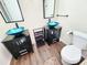 Bathroom featuring two vessel sinks, dark vanities and dark fixtures at 4102 Stonehenge Rd, Mulberry, FL 33860
