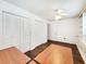 Bright bedroom with hardwood floors, white walls, closet with louvered doors, and a ceiling fan at 4102 Stonehenge Rd, Mulberry, FL 33860
