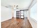 Bedroom with wood floors, ceiling fan, and sliding door to updated bathroom at 4102 Stonehenge Rd, Mulberry, FL 33860