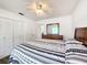 Bedroom with a bed, wooden headboard, dresser and double closet at 4102 Stonehenge Rd, Mulberry, FL 33860