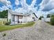 Exterior view showing a well-maintained white house, driveway, and landscaping at 4102 Stonehenge Rd, Mulberry, FL 33860
