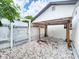 Gated white gravel area behind the house with a covered shelter and access to backyard at 4102 Stonehenge Rd, Mulberry, FL 33860