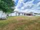 Backyard view of the home and the fenced-in yard, including a covered patio, a shed, and swing at 4102 Stonehenge Rd, Mulberry, FL 33860
