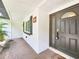 Covered front porch with a painted brick exterior and attractive front door with decorative glass at 4102 Stonehenge Rd, Mulberry, FL 33860