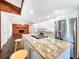 Updated kitchen with stainless appliances, island with cooktop, granite countertops and brick fireplace at 4102 Stonehenge Rd, Mulberry, FL 33860