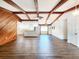 Spacious living room with vaulted ceilings, wood beams and floors, and a view of the kitchen at 4102 Stonehenge Rd, Mulberry, FL 33860
