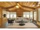 Bright living room with vaulted wood ceilings, brick fireplace, and large windows at 4102 Stonehenge Rd, Mulberry, FL 33860