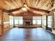 Cozy living room with brick fireplace, wood paneling and flooring, and ample natural light at 4102 Stonehenge Rd, Mulberry, FL 33860