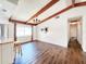 Spacious living room features wood beams, a chandelier, and stylish hardwood floors at 4102 Stonehenge Rd, Mulberry, FL 33860