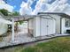 View of a white shed with a covered area on a gravel foundation and side access to backyard at 4102 Stonehenge Rd, Mulberry, FL 33860