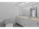Well-lit bathroom featuring a marble countertop, white cabinetry, and striking black and white patterned floor tiles at 4160 Player Cir # 109, Orlando, FL 32808