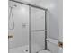 Clean bathroom featuring a glass-enclosed shower and white tile at 4160 Player Cir # 109, Orlando, FL 32808