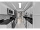 Well-lit kitchen featuring sleek black countertops and modern stainless steel appliances at 4160 Player Cir # 109, Orlando, FL 32808