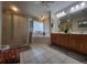 Bright bathroom featuring dual sinks, a garden tub, a large glass shower, and neutral tile flooring at 4471 Marsh Harbor Dr, Tavares, FL 32778