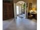Inviting foyer with tiled floors, decorative pillars, a wooden cabinet and a glass front door at 4471 Marsh Harbor Dr, Tavares, FL 32778