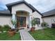 Charming home's front entrance with decorative plants, a stone walkway, and detailed front door at 4471 Marsh Harbor Dr, Tavares, FL 32778