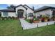 Charming home with flower pots along walkway, decorative lighting and a glass-paneled front door at 4471 Marsh Harbor Dr, Tavares, FL 32778