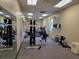 Well-equipped gym featuring modern workout machines, free weights, mirrored wall, and air conditioner unit at 4471 Marsh Harbor Dr, Tavares, FL 32778