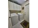 Functional laundry room featuring a white washer and dryer, storage cabinets, and neutral tile flooring at 4471 Marsh Harbor Dr, Tavares, FL 32778