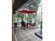Screened patio with a tiled floor, seating around a table with a red umbrella, and white lattice at 4471 Marsh Harbor Dr, Tavares, FL 32778