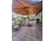 Screened-in patio featuring tile flooring, comfortable seating, an outdoor grill and large umbrellas at 4471 Marsh Harbor Dr, Tavares, FL 32778