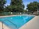 Inviting community pool area with clear blue water, poolside seating, and well-maintained surrounding greenery at 4471 Marsh Harbor Dr, Tavares, FL 32778