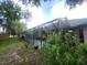 View of a screened patio with seating, greenery, and a partial view of the yard at 4471 Marsh Harbor Dr, Tavares, FL 32778