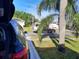 View of a street sweeper truck driving down a neighborhood street with houses and palm trees at 4471 Marsh Harbor Dr, Tavares, FL 32778