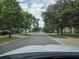 Street view featuring tree-lined street with well-maintained houses at 4471 Marsh Harbor Dr, Tavares, FL 32778