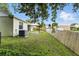 This backyard features a wood fence, a green lawn, and mature trees at 6125 Morningdale Ave, Lakeland, FL 33813