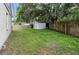 This backyard features a wood fence, a storage shed, and a green lawn at 6125 Morningdale Ave, Lakeland, FL 33813