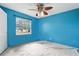 This bedroom features a ceiling fan, window, and blue painted walls at 6125 Morningdale Ave, Lakeland, FL 33813