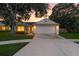 Charming single-story home with a two-car garage, mature trees, and a well-manicured lawn at sunset at 6125 Morningdale Ave, Lakeland, FL 33813