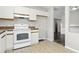 This kitchen features white cabinets, tile floors, and white appliances at 6125 Morningdale Ave, Lakeland, FL 33813
