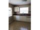 Functional kitchen features white cabinetry, stainless steel sink, and a window with natural light at 6125 Morningdale Ave, Lakeland, FL 33813