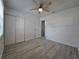 Bright bedroom with a ceiling fan, wood-look floors, and a closet at 17 Oak Loop, Ocala, FL 34472